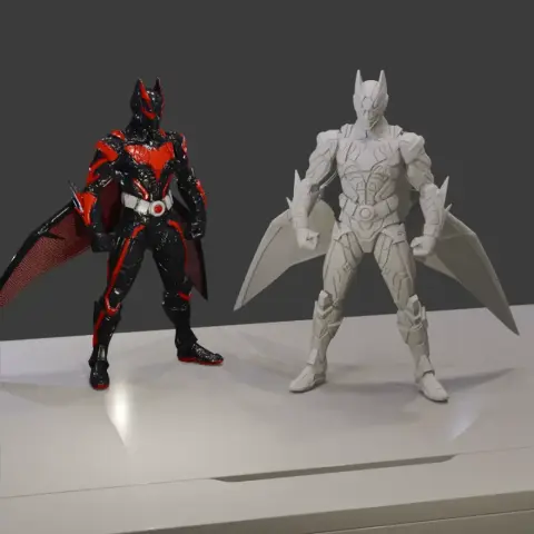 Two Batman figures in futuristic armor; one painted black and red, the other unpainted with bat-like wings.