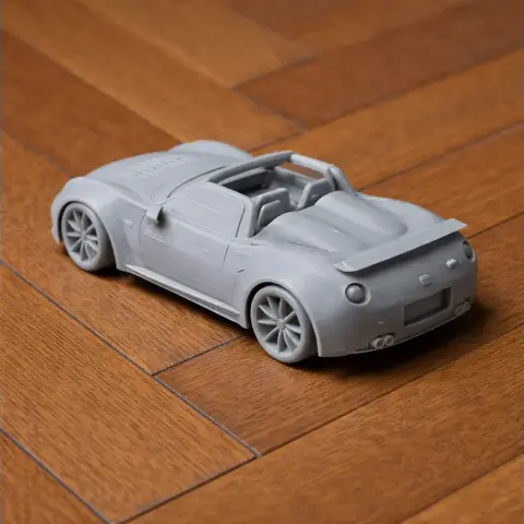 3D-printed scale model of an Abarth 1000 SP sports car, positioned on a wooden floor.