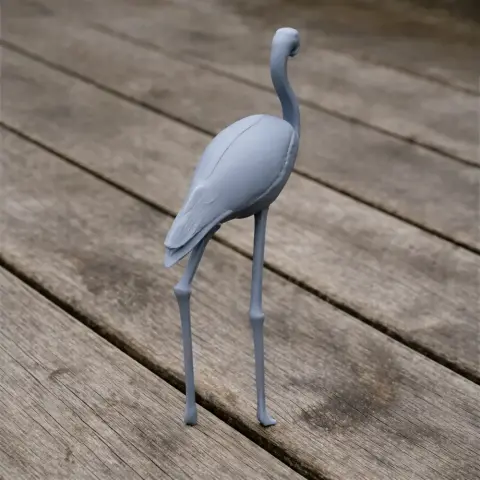 A 3D-printed model of an American Flamingo standing on a wooden surface.