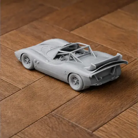 3D-printed scale model of Abarth 2000 Sport on a wooden surface, showcasing sleek curves and rear spoiler.