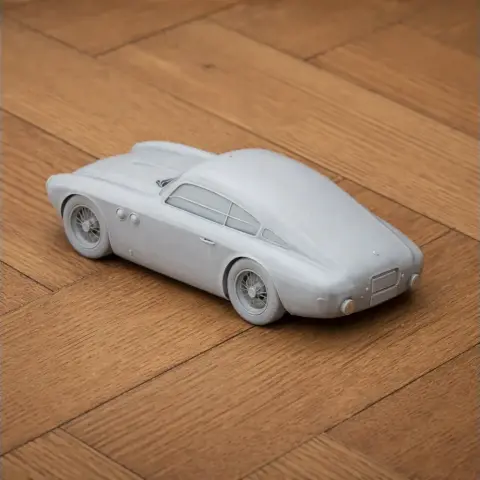 3D-printed scale model of a vintage Abarth 205A Berlinetta car on a wooden surface.