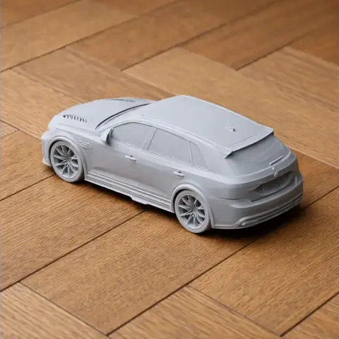 3D-printed gray scale model of a sporty vehicle, shown on a wooden surface.