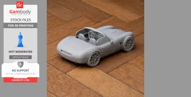 Gray 3D-printed AC Cobra GT Roadster model on wooden surface, showcasing details like wheels and interior.