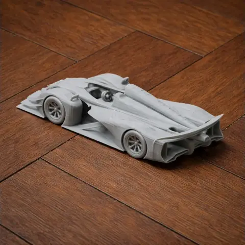 3D printed model of a sleek race car on a wooden surface.