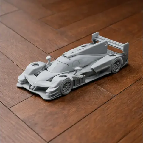 3D printed model of a sleek, aerodynamic race car with a large rear wing on a wooden surface.