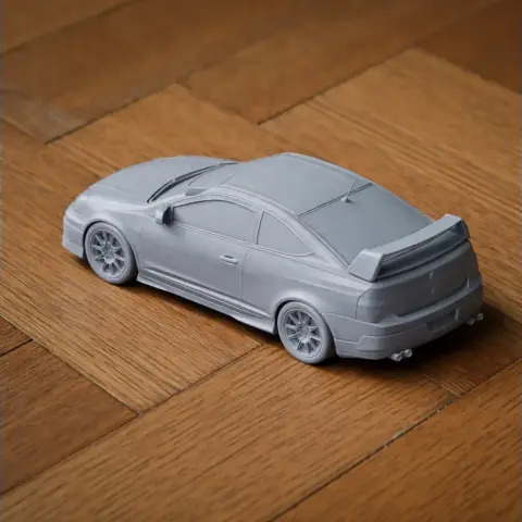 Gray 3D-printed Acura RSX model on a wooden surface, detailed body and wheels.