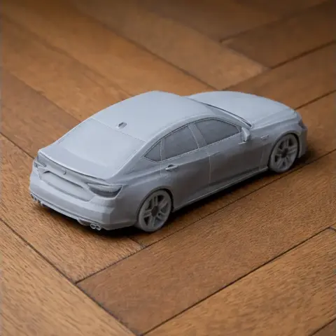 Gray 3D-printed Acura TLX model on a wooden floor, viewed from the rear side.