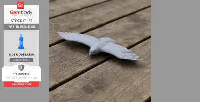 Gray 3D-printed model of a soaring bird with wings spread, displayed on a wooden surface.