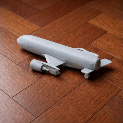 3D printed model of an Airbus A330 on a wooden floor, unpainted and showing landing gear detail.