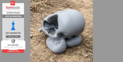 A 3D-printed Asian elephant skull model on rough, sandy terrain.
