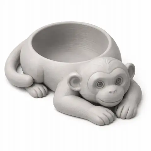 3D model of a monkey-shaped bowl with a cute, smiling face, lying with paws forward.