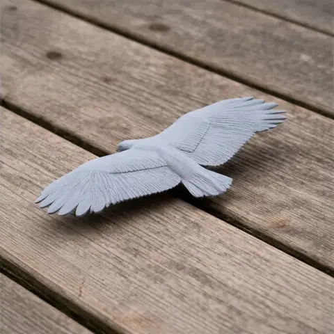 3D printed model of a griffon vulture with wings spread, on a wooden surface.