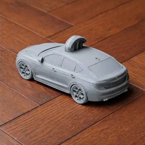 Gray 3D printed model of an Alfa Romeo car on wooden floor, detailed with a sunroof and intricate wheels.