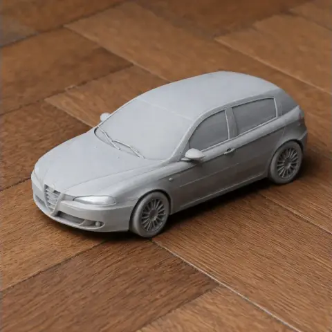 3D printed model of an Alfa Romeo 147 car on a wooden surface.