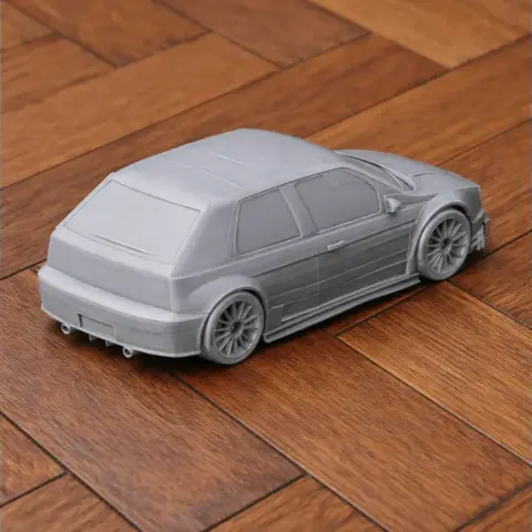 3D-printed gray model of an Alfa Romeo 155 scale vehicle on a wooden surface.