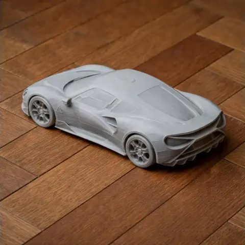 3D-printed model of a sleek sports car on a wooden surface.