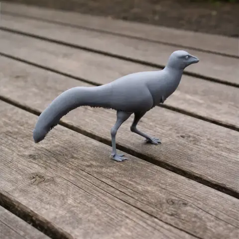 Gray 3D-printed model of a Mononykus dinosaur standing on wooden planks.