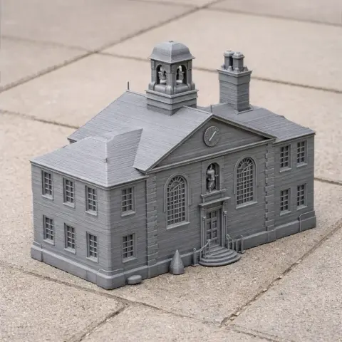 3D-printed model of a detailed, historic-style building with arch windows and a central clock tower.