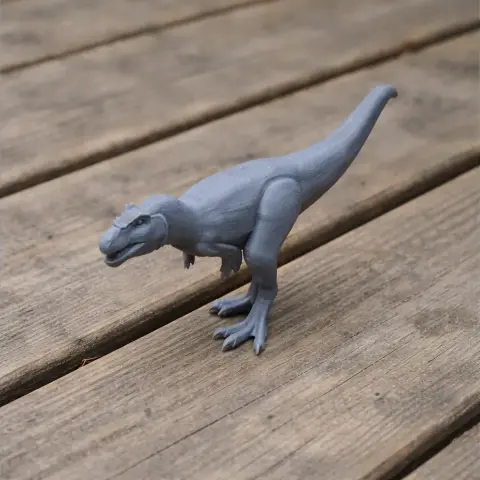Gray 3D printed model of a Nanuqsaurus dinosaur on a wooden surface.