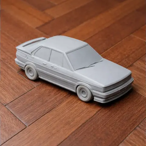 3D printed model of a classic Alfa Romeo 75 car on a wooden surface.