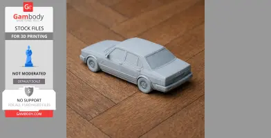 3D-printed model of a classic Alfa Romeo Alfetta car in gray on a wooden surface.