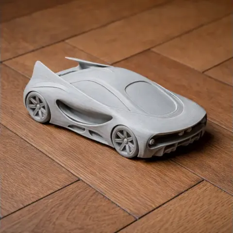 Futuristic Alfa Romeo BAT model car in gray, designed for 3D printing, displayed on wooden floor.