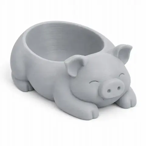 Gray 3D-printed pig-shaped bowl with facial features and curled legs, used as a wall hook.