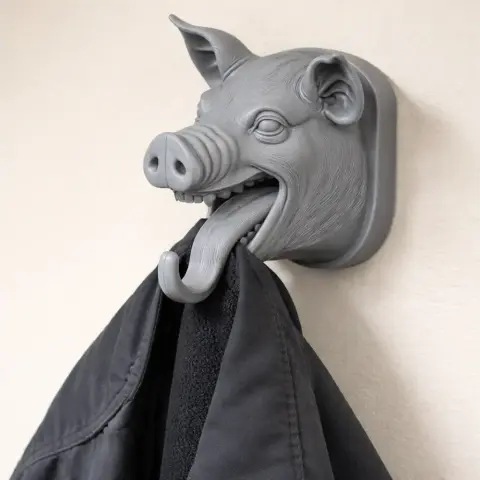 3D pig head wall hook holding a coat, designed for keys and garments.