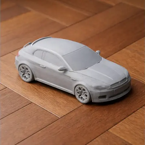 3D-printed model of an Alfa Romeo Brera, detailed and unpainted, on a wooden surface.