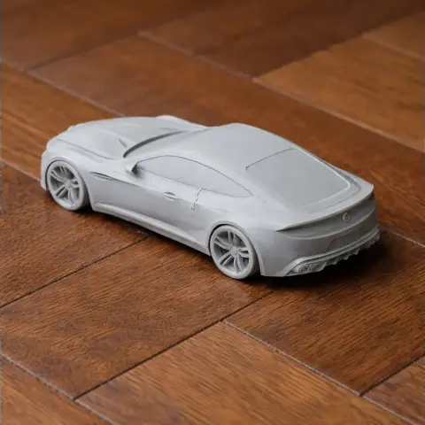 3D-printed model of a sleek Alfa Romeo Giulia on a wooden surface.