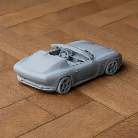 3D-printed model of an Alfa Romeo Disco Volante, showcasing sleek design on a wooden surface.