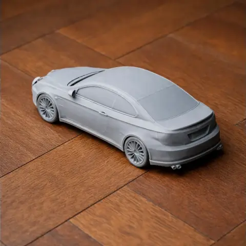 3D printed model of a sleek Alfa Romeo GT car on a wooden surface.