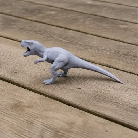 Gray 3D-printed Ngexisaurus model with open mouth, standing on wooden surface.