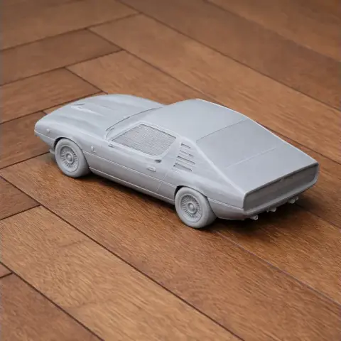 3D-printed model of an Alfa Romeo Montreal car on a wooden floor.