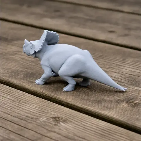 A 3D-printed model of an armored dinosaur with a frilled neck, standing on a wooden surface.