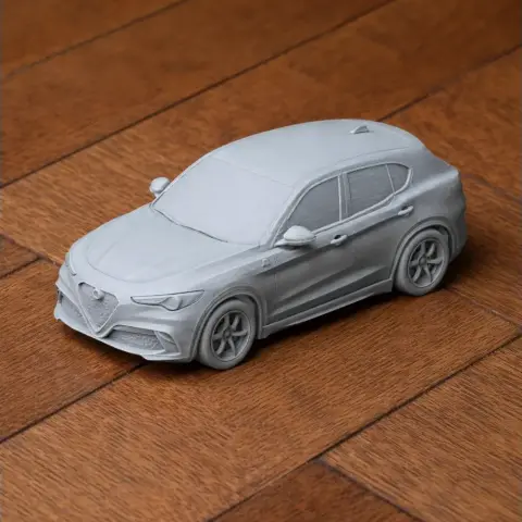 3D-printed Alfa Romeo Stelvio model on a wooden surface.