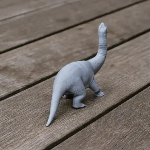 3D printed model of an Ohmdenosaurus dinosaur standing on a wooden surface.