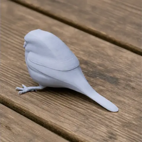 3D printed model of an oilbird, prehistoric-style, on a wooden surface.