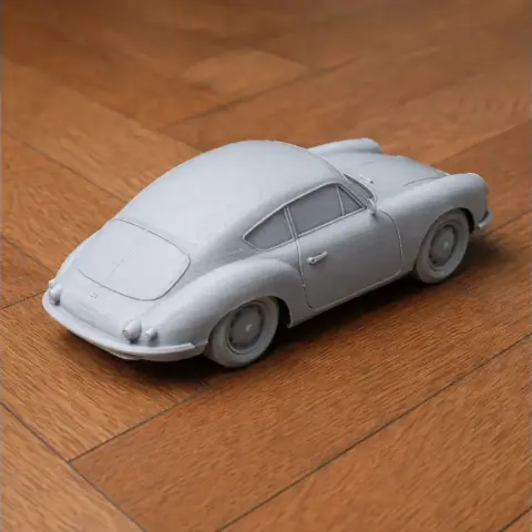 3D printed model of a vintage Alpine A106 car on a wooden surface.