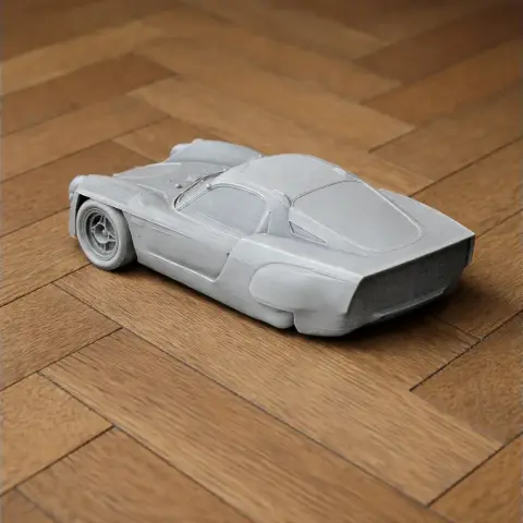 3D printed model of an Alpine A220 race car on a wooden floor.