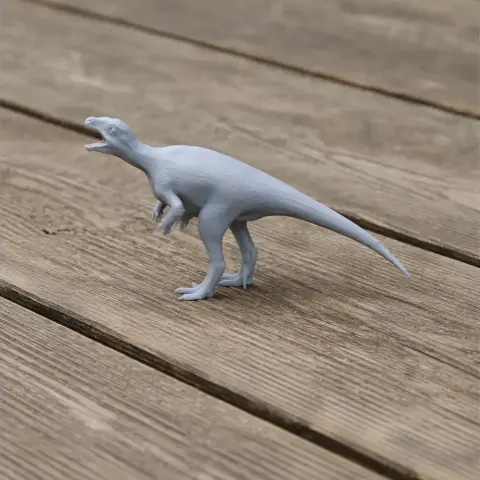 Gray 3D-printed Orodromeus dinosaur model standing on a wooden surface.