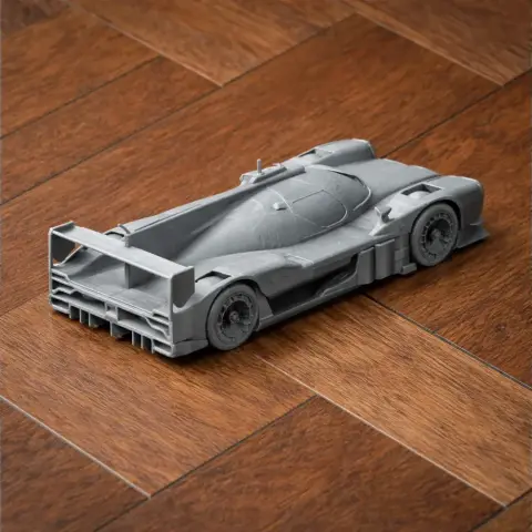 3D-printed scale model of the Alpine A480 race car, in gray, displayed on a wooden floor.