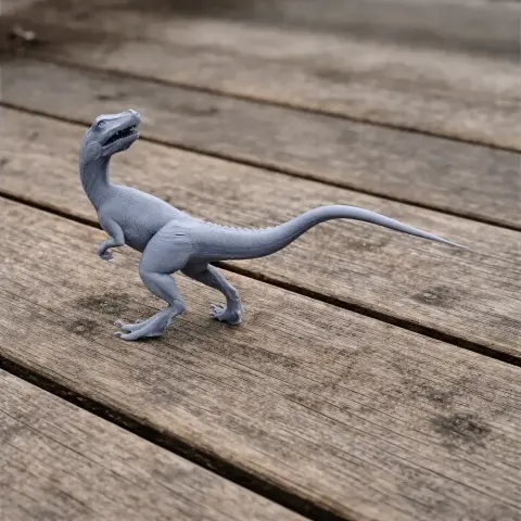 Gray Overoraptor 3D print on wooden surface, standing upright with mouth open and long tail extended.