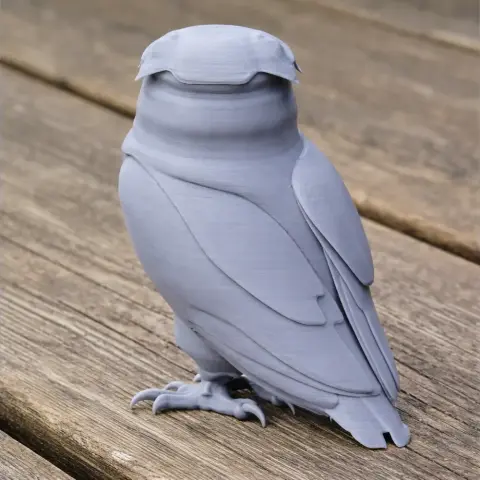 3D-printed model of a stylized, prehistoric owl with smooth textures on a wooden surface.