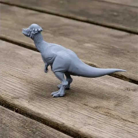 Gray 3D-printed Pachycephalosaurus model on a wooden surface.