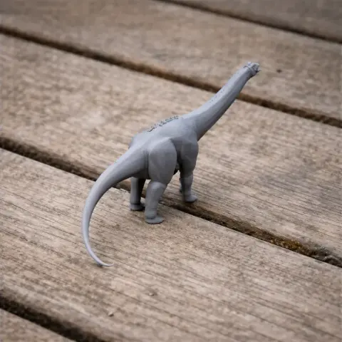 Gray 3D model of a Pakisaurus dinosaur standing on a wooden surface.