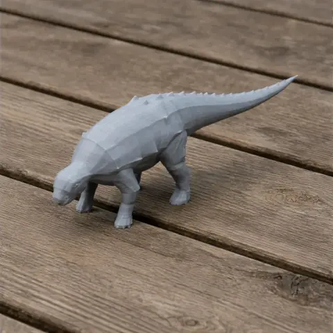 A gray, low-poly Panoplosaurus 3D print model stands on a wooden surface.