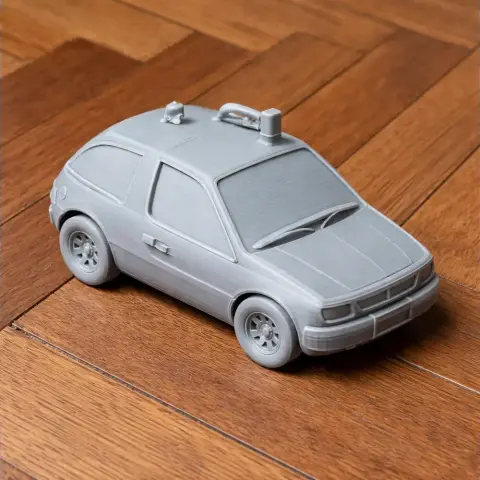 3D printed AMC Pacer scale model car on a wooden floor, detailed with smooth surfaces and distinct features.