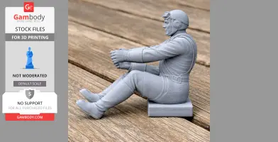 3D printed WWII pilot figure seated, wearing a flight suit and helmet, positioned on a wooden surface.