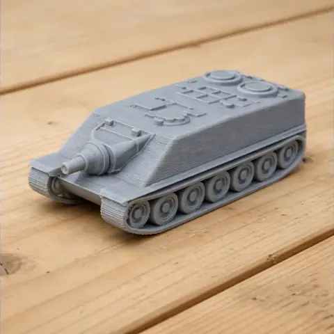 Gray 3D-printed tank model with tracks and a long barrel, displayed on a wooden surface.